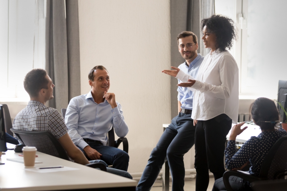 Four individuals in discussion in office setting