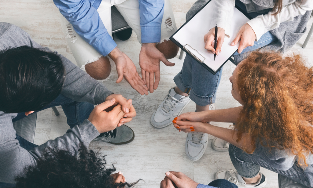 Birds eye view of group of individuals engaged in a discussion in a clinical setting